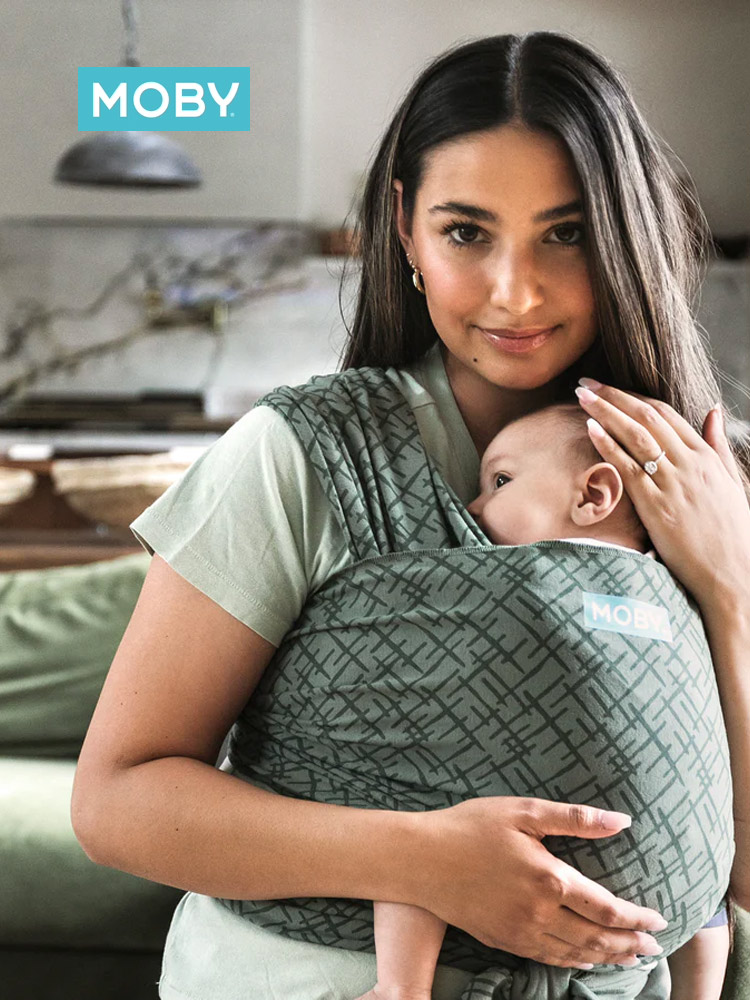 a mother cuddling her baby in a green moby wrap