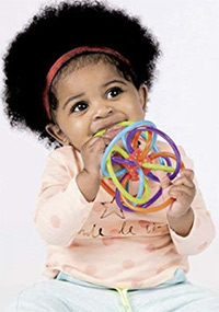 a baby holding and chewing on the manhattan winkel rattle and teether toy
