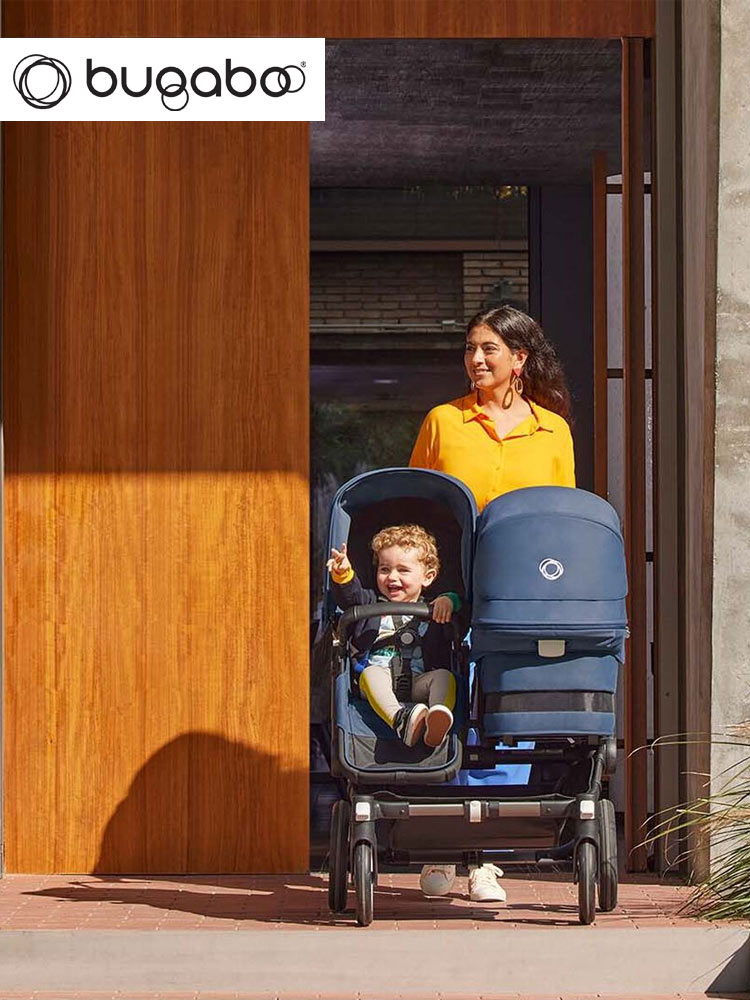 a mom pushing two children through a doorway in the bugaboo donkey 3 duo stroller
