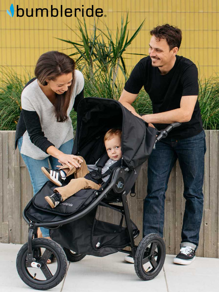 parents engaging with toddler boy riding in the bumbleride indie stroller