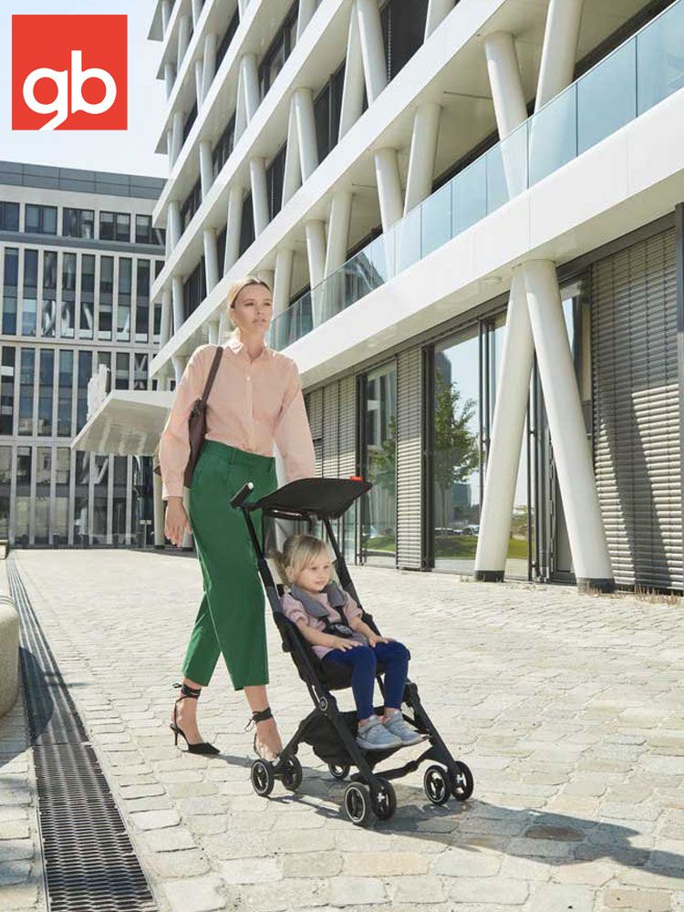 a mother pushing the gb pockit stroller through a business park