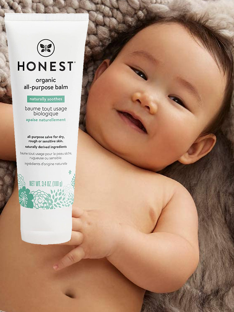 a smiling baby with soft skin and a tube of honest company all-purpose balm