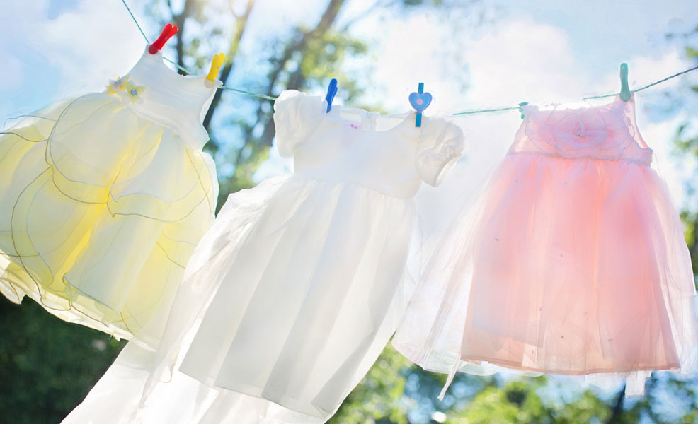 clean baby clothes hanging out to dry in the sun