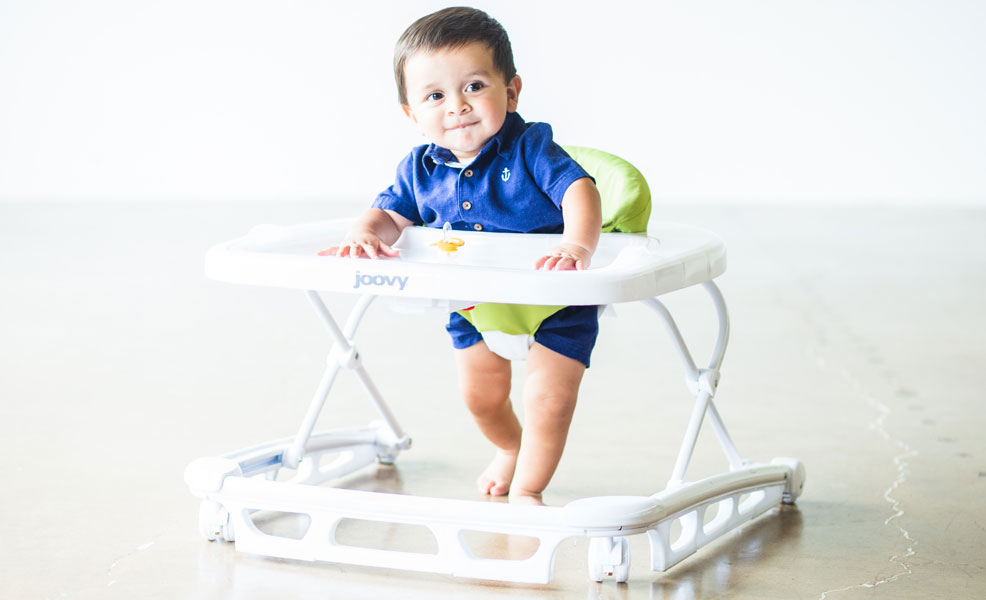a smiling baby using a joovy spoon baby walker