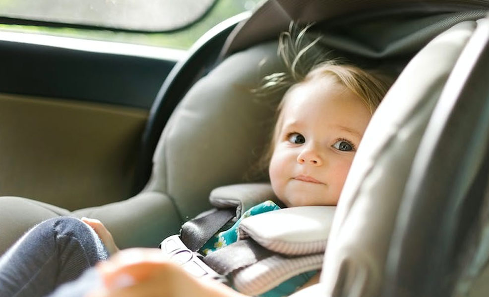 smiling baby buckled into cheap infant car seat