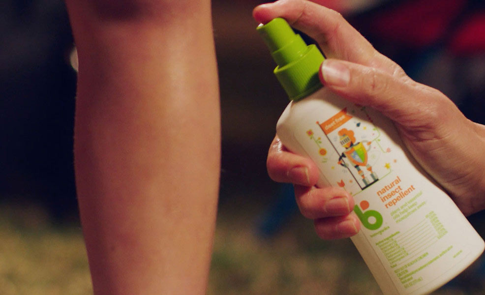 a childs leg being sprayed with babyganics natural insect repellent spray