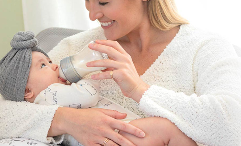 a mom feeding a baby with the chicco duo baby bottle