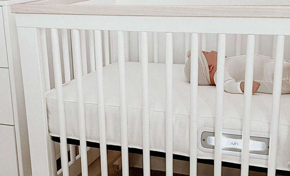 baby sleeping in crib with a contours vibes crib mattress