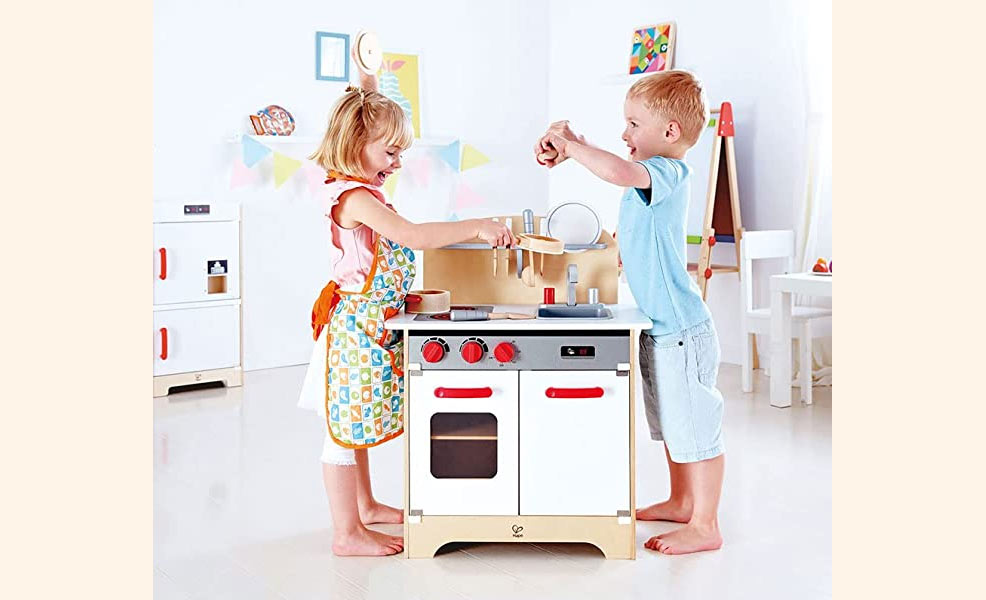 girl and boy playing together in play kitchen