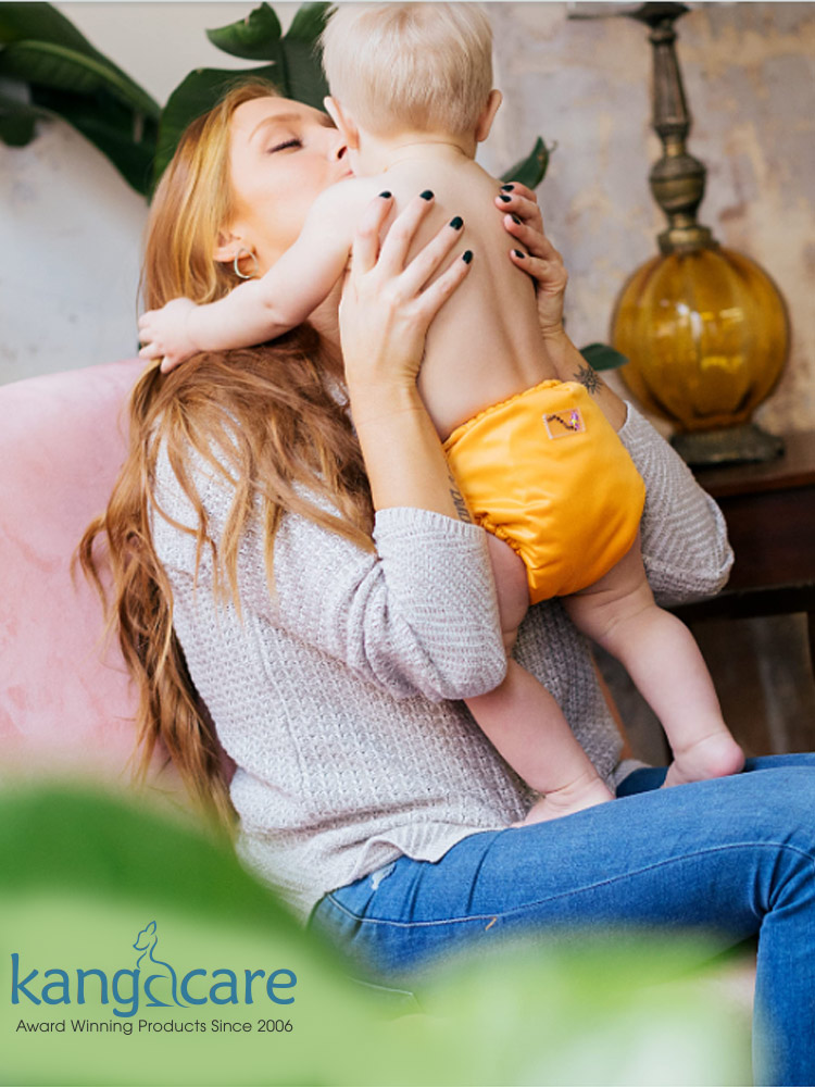 a mom picking up and kissing a baby wearing a rumparooz cloth diaper