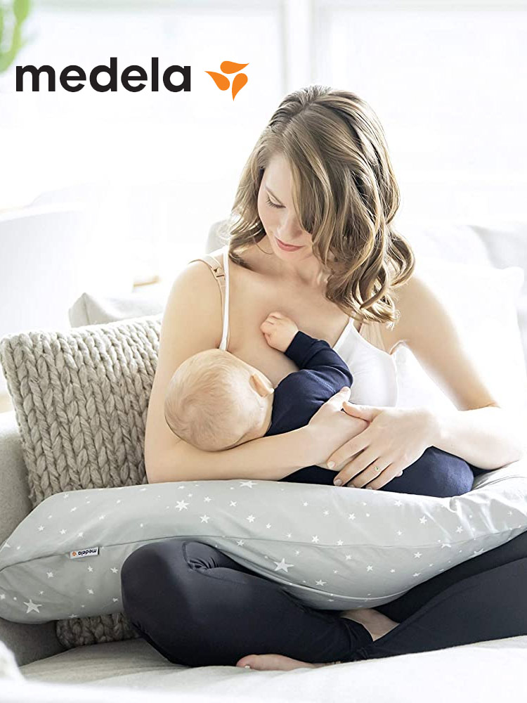 a mom breastfeeding a baby on the medela nursing pillow