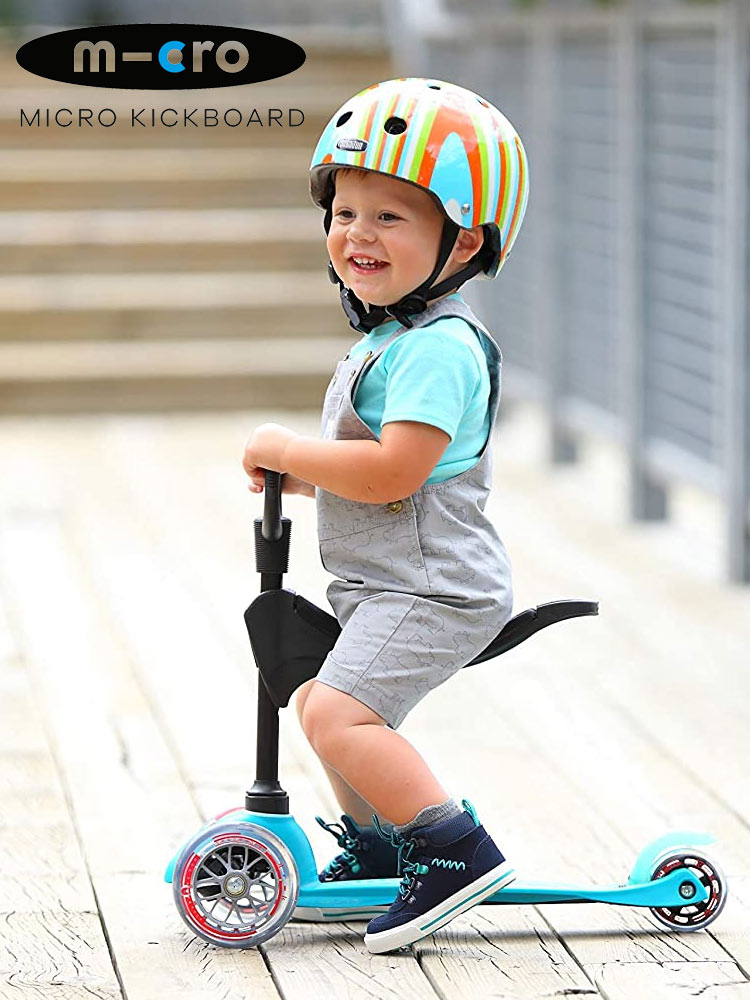 a toddler sitting on the micro mini 3in1 sit stand deluxe scooter
