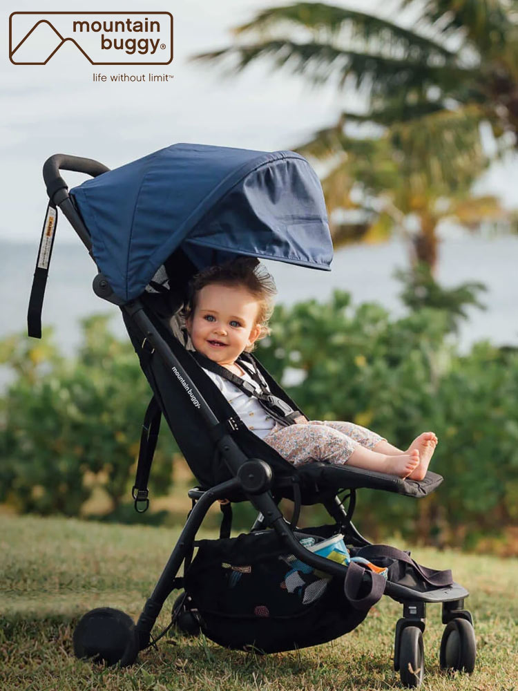 a baby smiling while sitting in the mountain buggy nano travel stroller