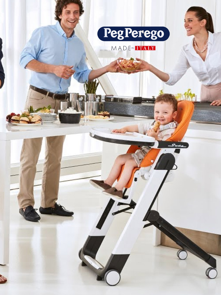 parents working in the kitchen while a smiling toddler boy sits in the peg perego siesta high chair