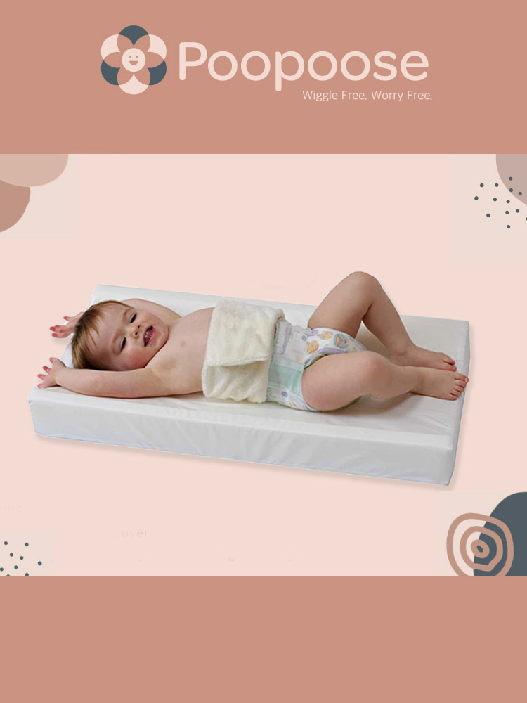 a baby laying down on and buckled into the poopoose changing pad