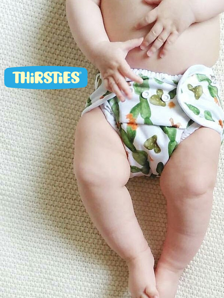 a baby laying down wearing a thirsties duo wrap snap cloth diaper
