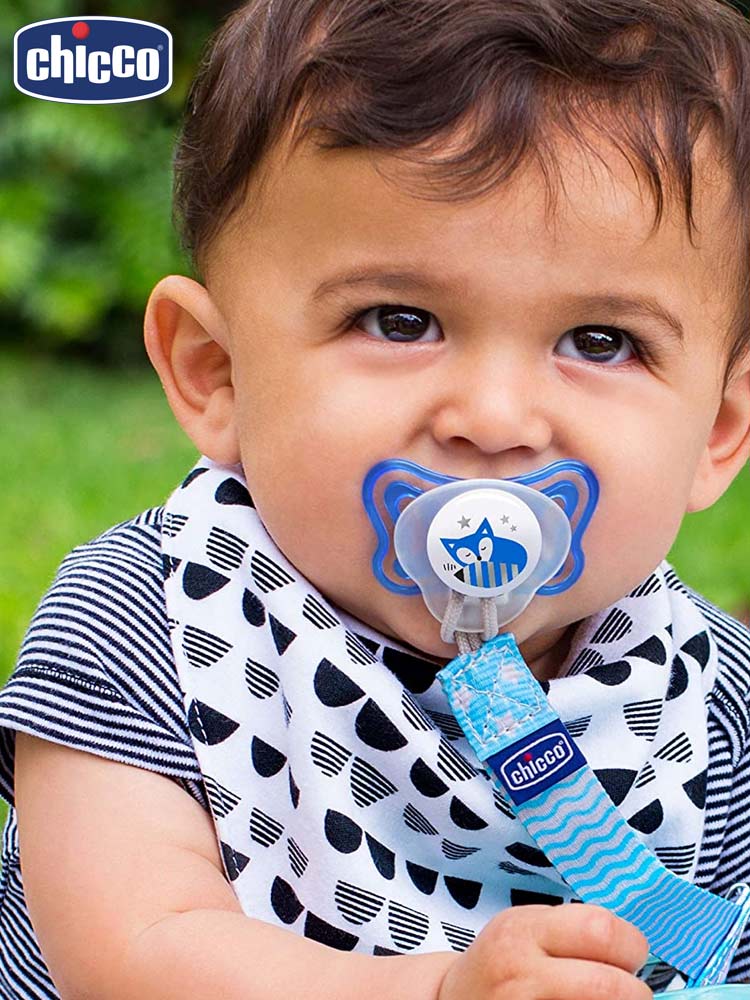 a boy with a blue chicco physioforma orthodontic pacifier in his mouth