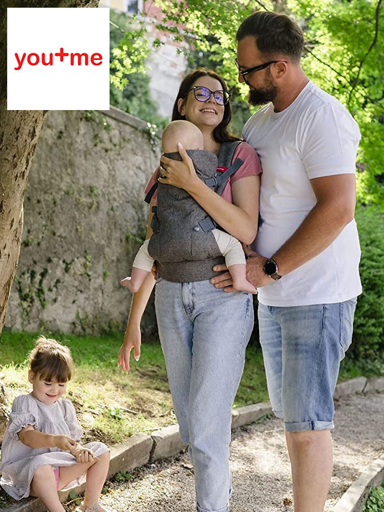 a father mother and toddler and a baby in a you+me ergonomic baby carrier