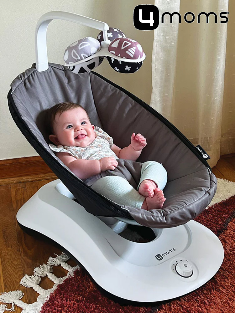 a baby boy smiling in the 4moms rockaroo baby swing