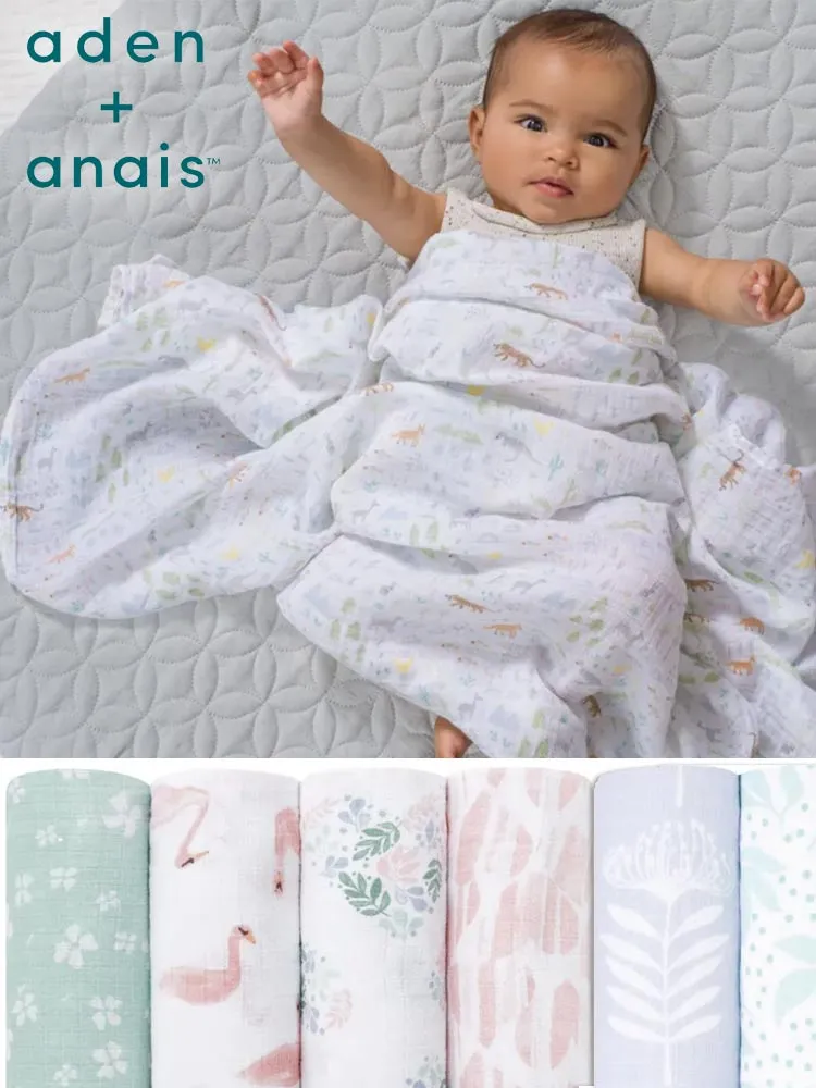 a baby wrapped in Aden and Anais muslin swaddle blankets