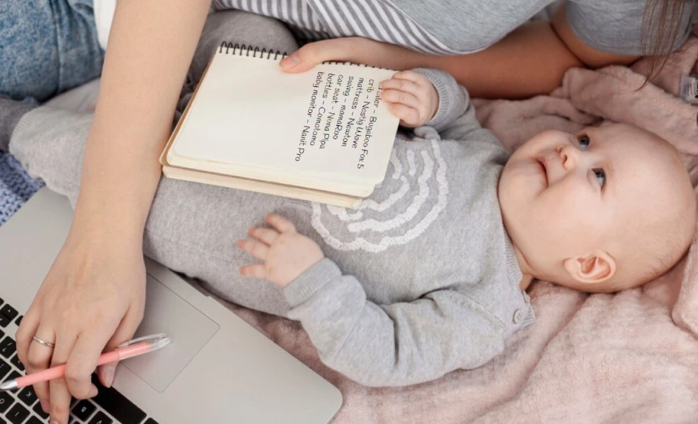 parents comparing baby products on laptop surrounded by baby gear items