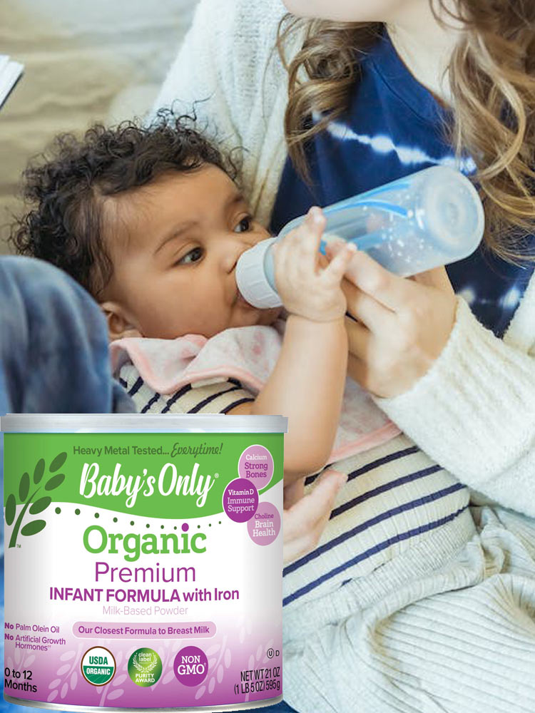 a parent feeding a baby from a bottle filled with prepared babys only premium infant formula