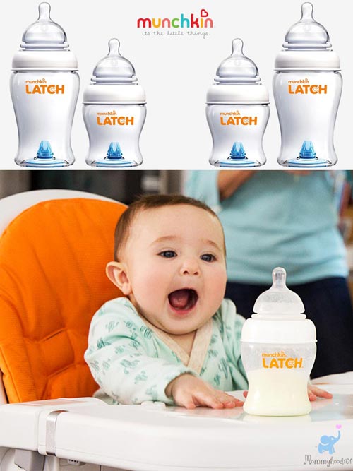 a baby boy sitting in a high chair reaching for a munchkin latch baby bottle filled with milk