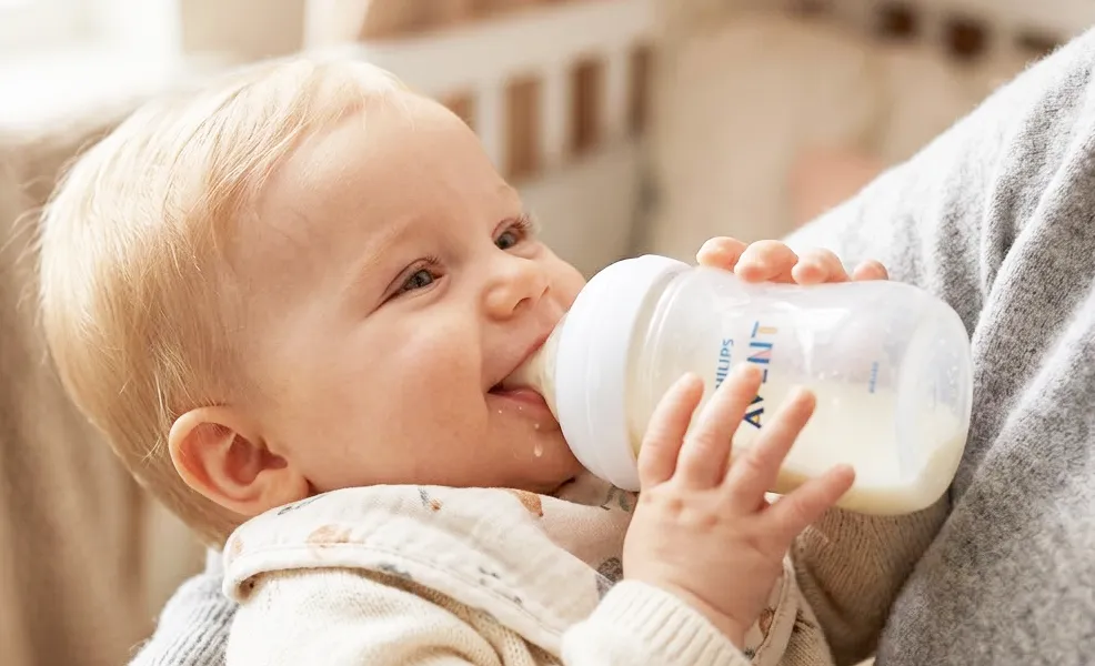 assortment of organic baby formulas atop wooden pedestals with a plant in the background