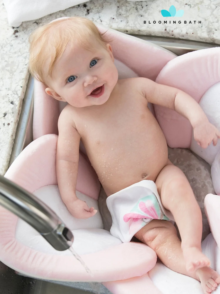 a smiling baby being bathed in a blooming lotus baby bathtub