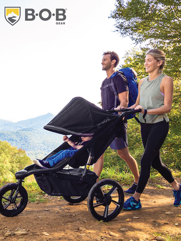 parents walking on a trail in the mountains while pushing a toddler in the bob alterrain pro stroller