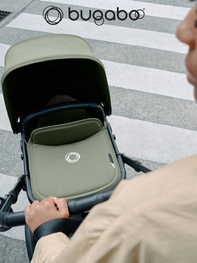 a male parent pushing a baby through an urban environment in the bugaboo fox 5 stroller