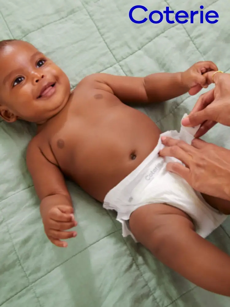 a baby getting a diaper change wearing a Coterie diaper