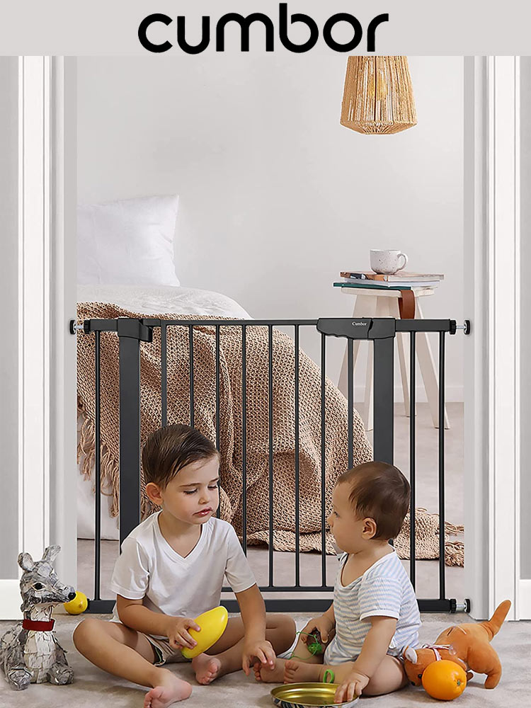 two babies sitting and playing behind a cumbor baby gate