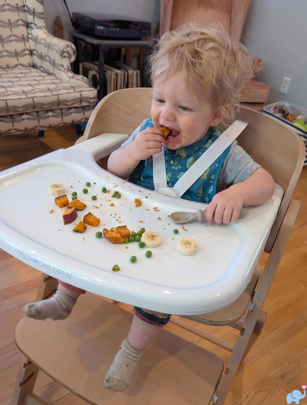 Ten-month-old baby eating finger foods in the Delta Children Crave High Chair infant configuration