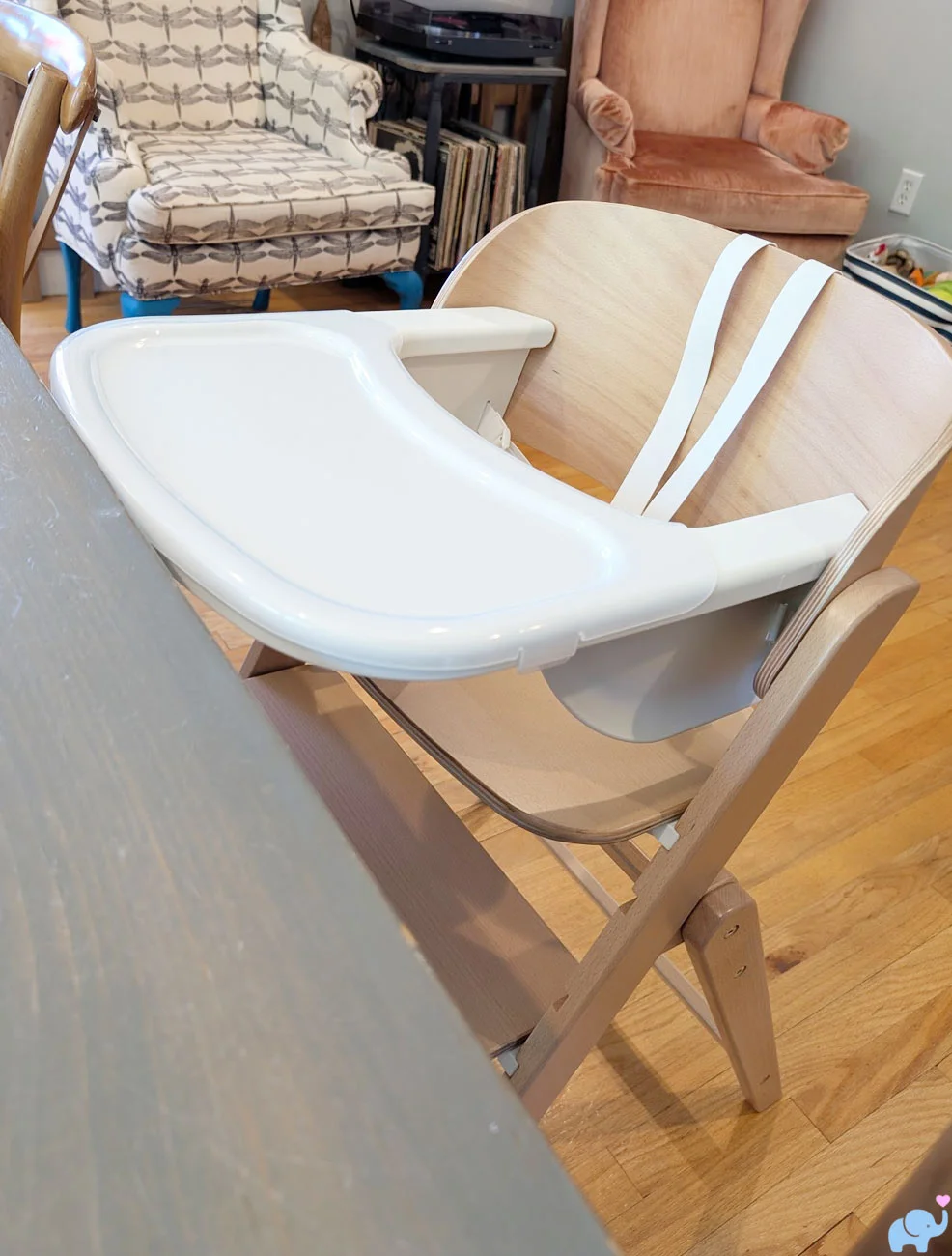 Delta Children Crave High Chair in infant mode with tray positioned beside a standard dining table
