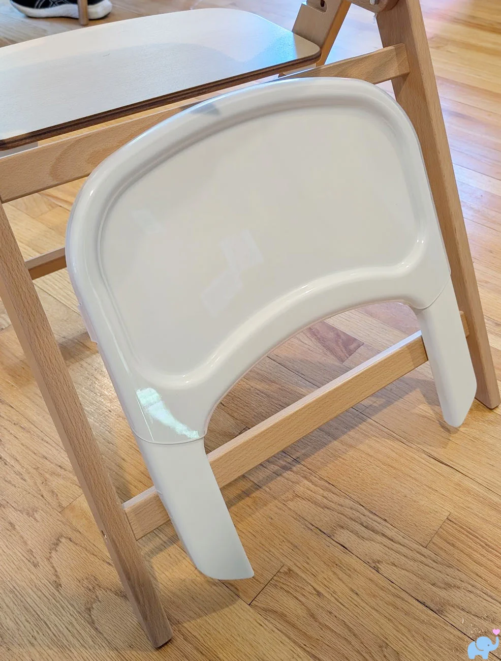 Delta Children Crave High Chair tray hanging from its rear storage hook while the chair is folded