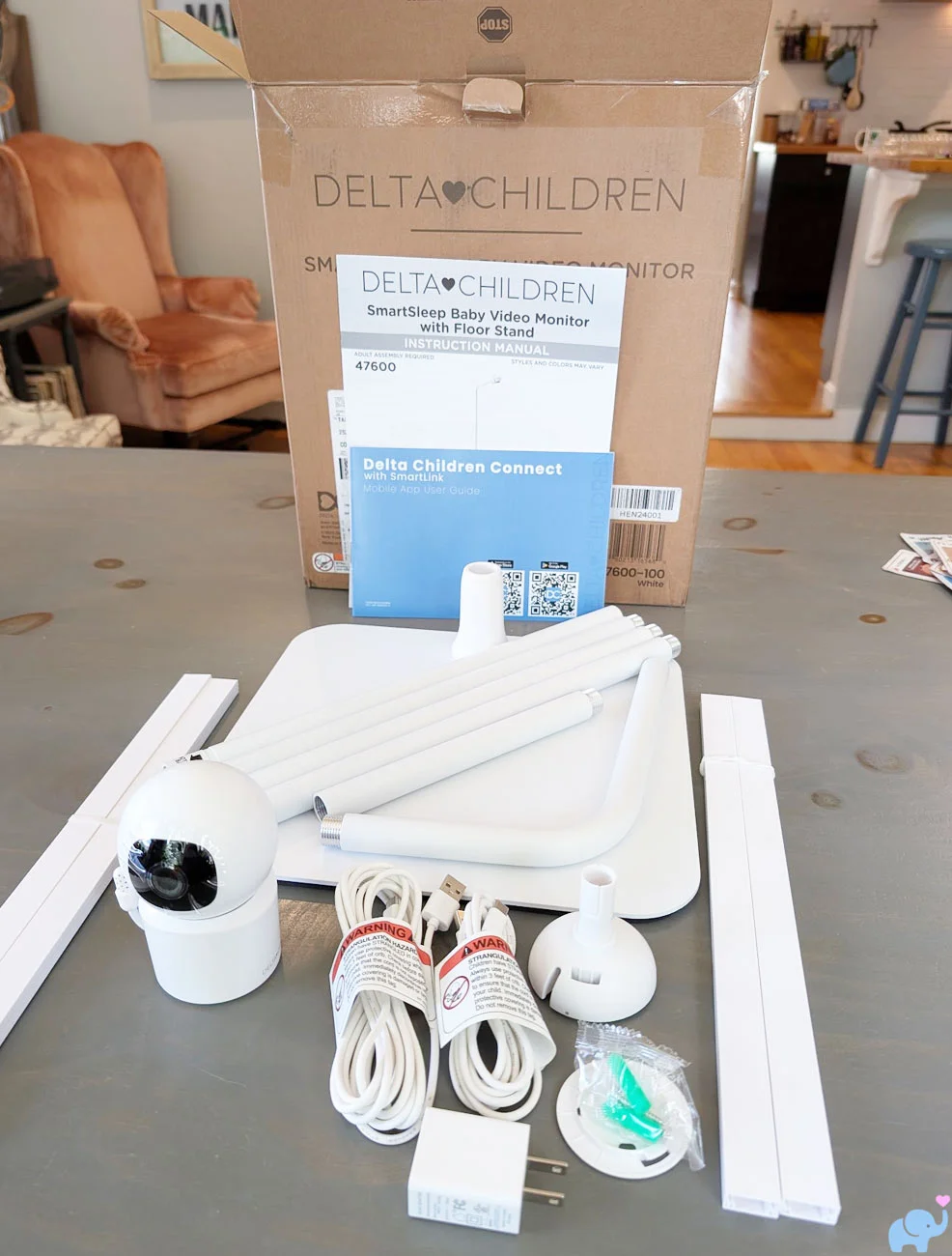 All Delta Children Smart Sleep Baby Monitor components unpacked including tower sections base camera mounts power cords cord covers and manuals