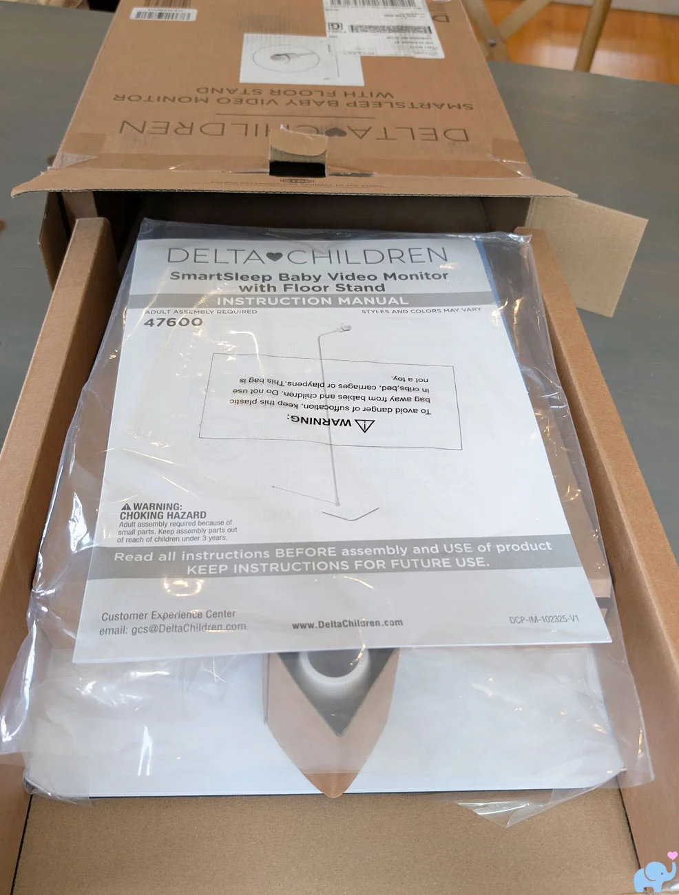 Delta Children Smart Sleep Baby Monitor components sliding out of the retail box during unboxing
