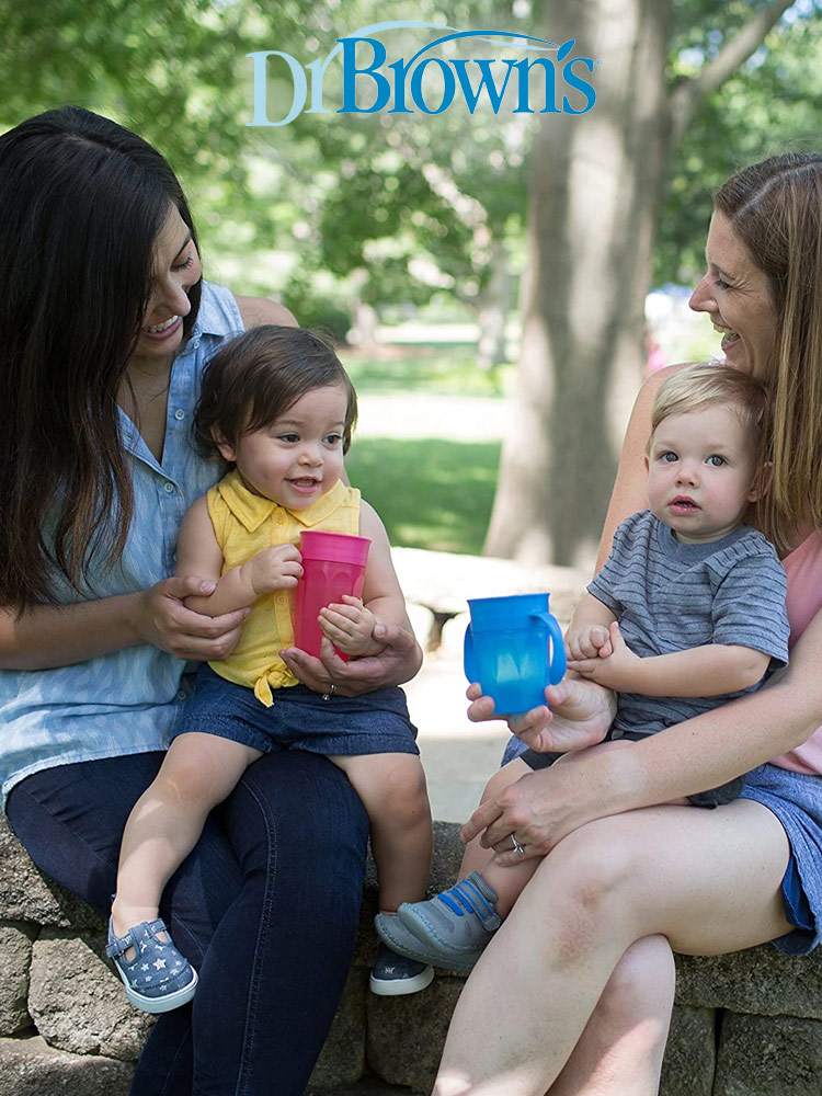 parents sitting with their children in the park as they drink from the dr browns cheers 360 spoutless training cups