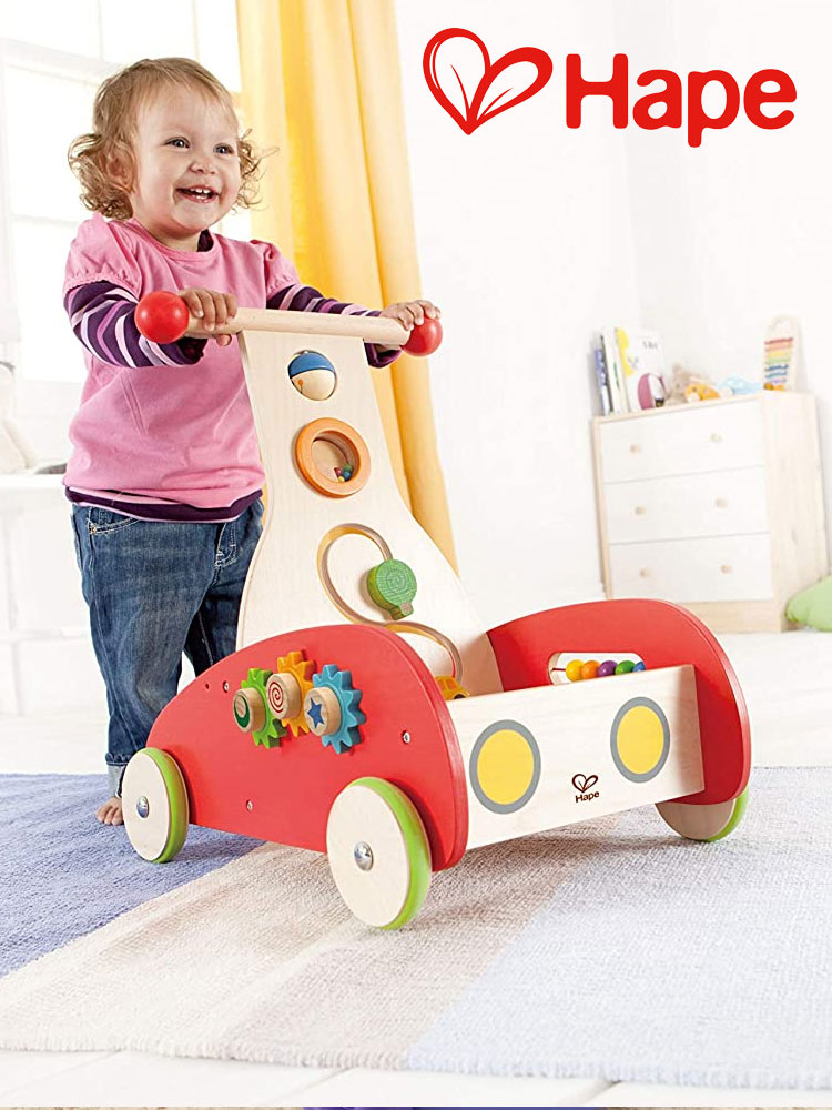 a smiling toddler girl pushing the hape wonder walker