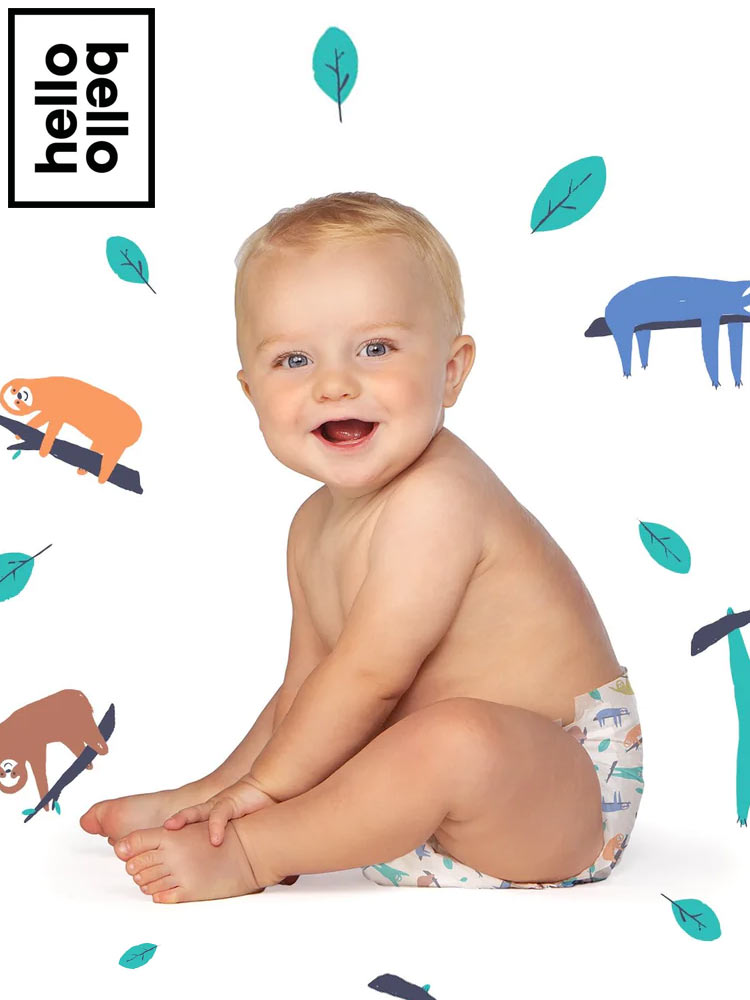 a baby sitting and smiling at the camera while wearing a hello bello diaper