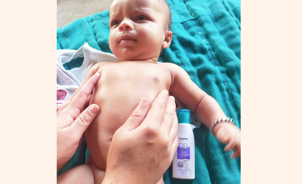 baby lotion being rubbed on baby tummy