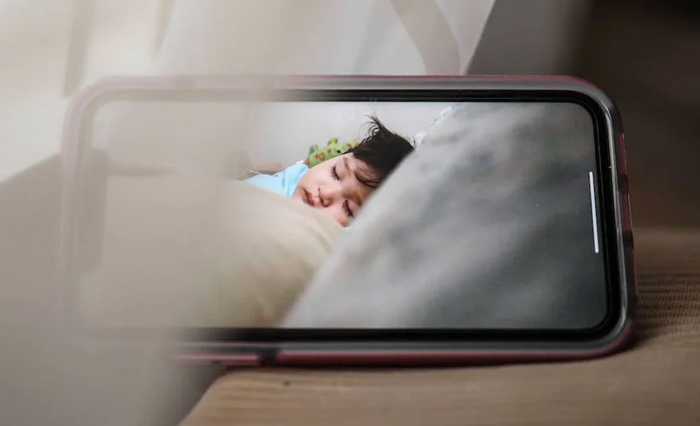 smartphone showing a live video feed of sleeping baby