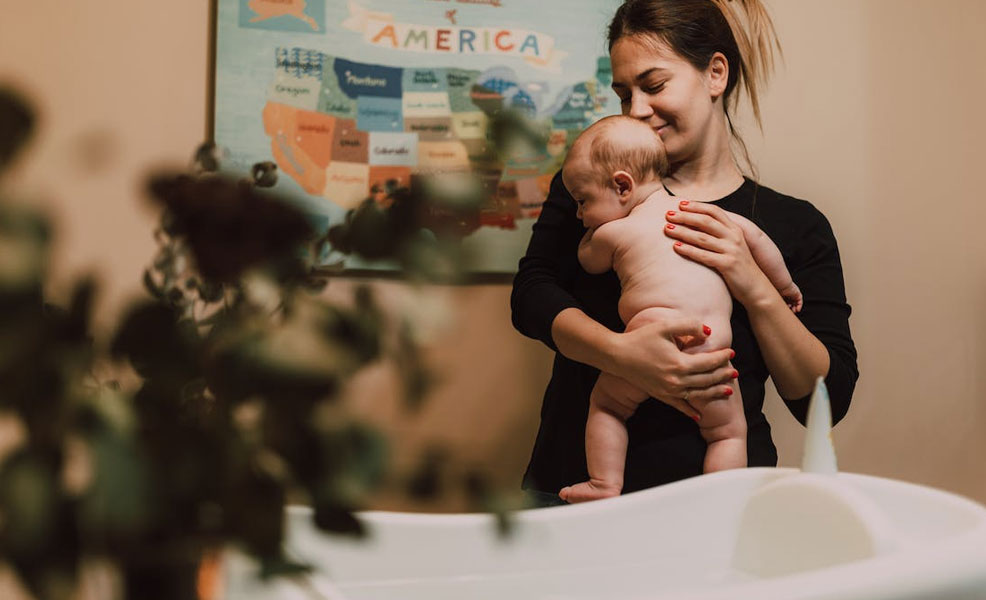 mom holding baby ready for bath time