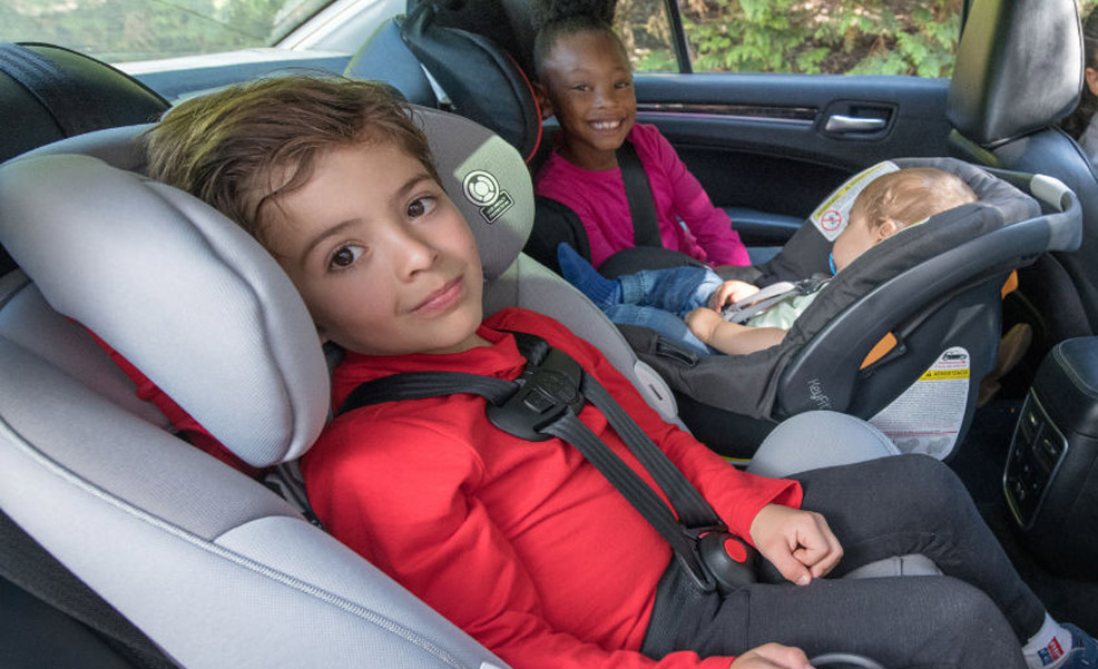 mom trying out a car seat with child