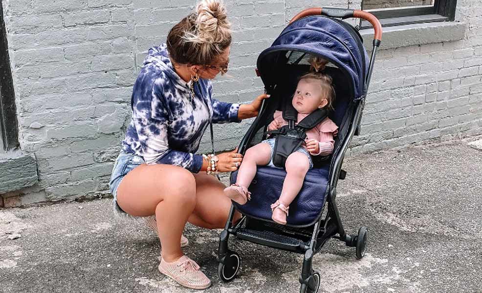 a mom looking at a baby riding in a contours bitsy elite stroller