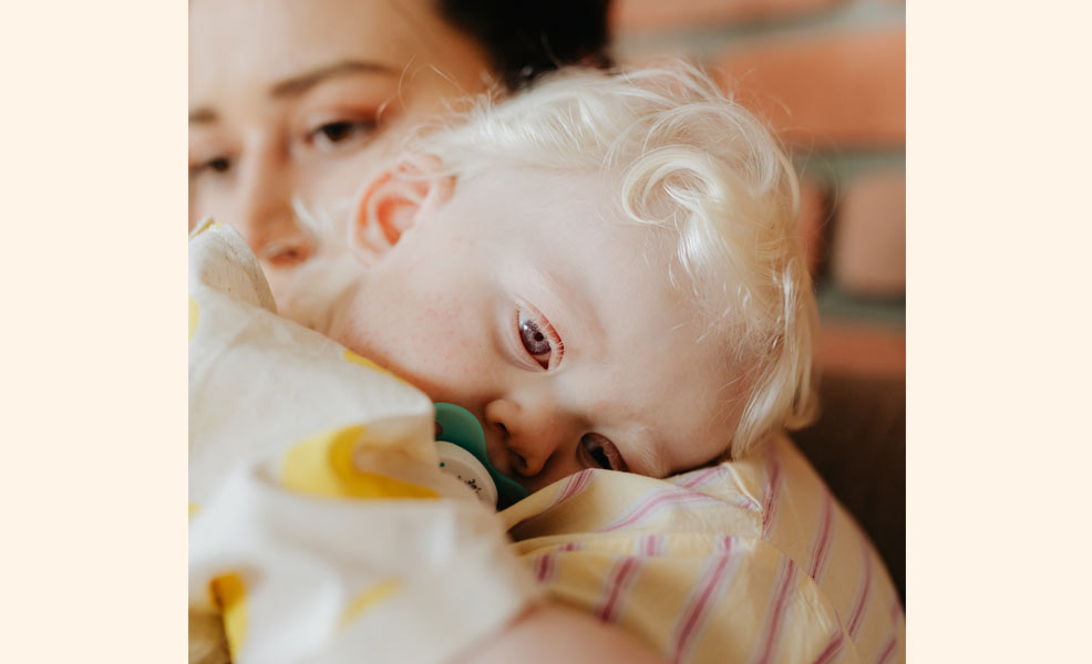 coughing baby on moms shoulder