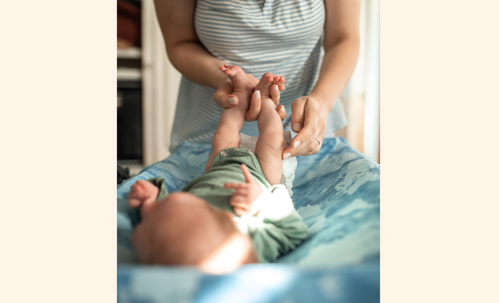 baby diaper change on changing pad with mom