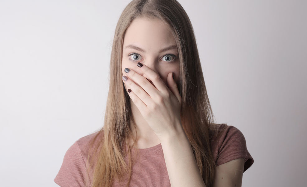 a mom covering her nose with her hand due to the smell of dirty diapers