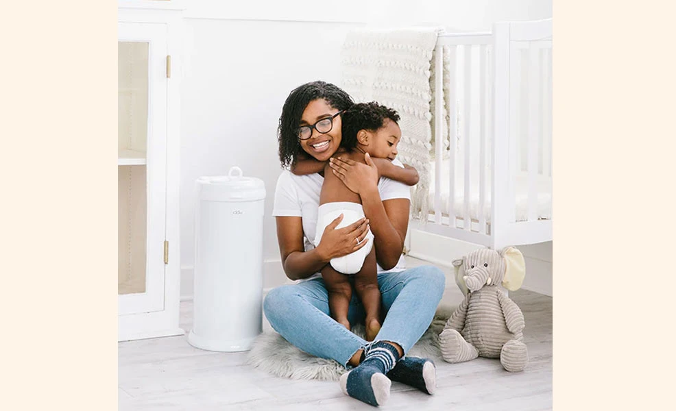 mom and baby with ubbi diaper pail
